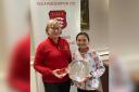 Coco Locke is presented with her Spring Meeting trophy by Essex County Golf Association president Nicola Thomas