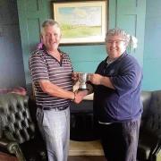 VICTORIOUS: Gavin Cowell receives Frinton Golf Club’s Past Captain’s Trophy from last year’s captain, Luc Gagne.
