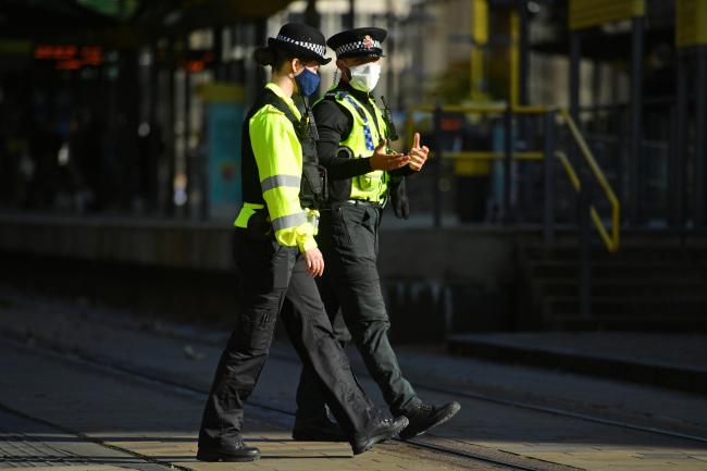 Caution - police officers wearing face masks in St Peter's Square, Manchester. Picture: PA