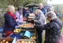 FRUIT FARE: Trust members dishing out apples at a previous event in the Railway Cottage gardens