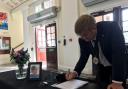 TOUCHING TRIBUTE: Tendring Council chairman Peter Harris signs the Clacton Town Hall's Book of Condolence