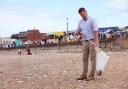 Clean - A man litter picking on a beach