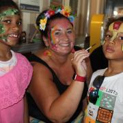 PAINTING - Remiyah and Keiro Southam get their faces decorated by Claire from Face Paint and Glitter Station. Credit: Nigel Brown
