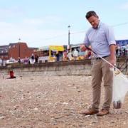 Clean - A man litter picking on a beach